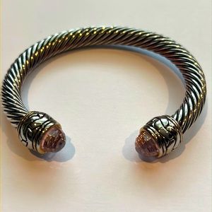 Silver and gold colored bracelet with pink Chrystals at the opening.